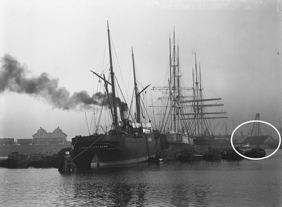 Foto van het schip ‘Norma Flensburg’ in het Oosterdok, november 1894. Rechts is op de achtergrond de Sluisdeurenloods zichtbaar. | Foto: Jacob Olie, beeldbank Stadsarchief Amsterdam (10019A000398).